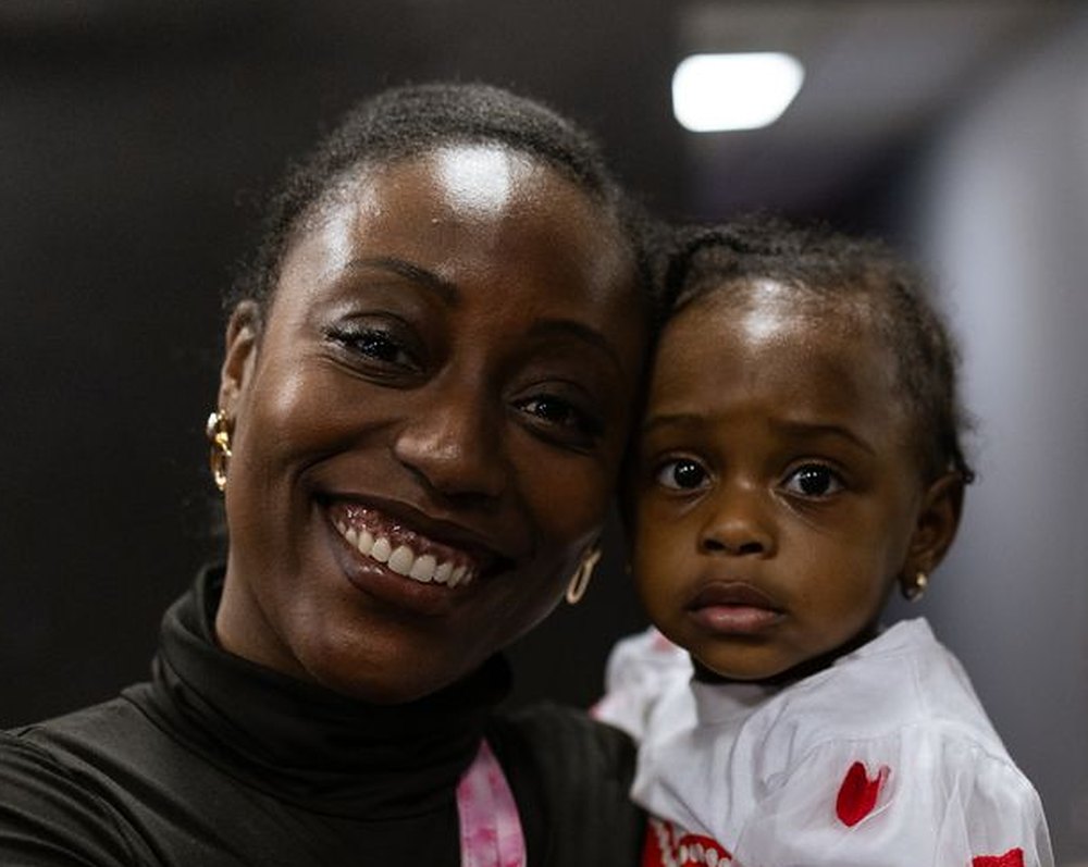 A smiling woman holding a little girl at NDAC