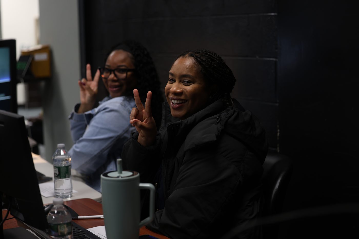 Two volunteers smiling at the welcome desk