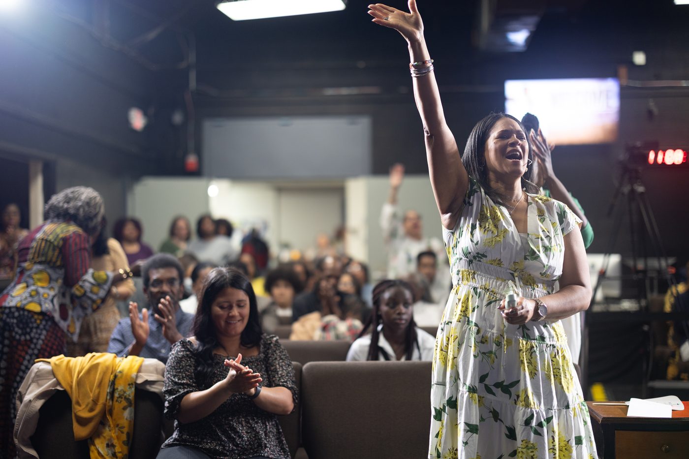 A church member worshipping with a raised hand during service